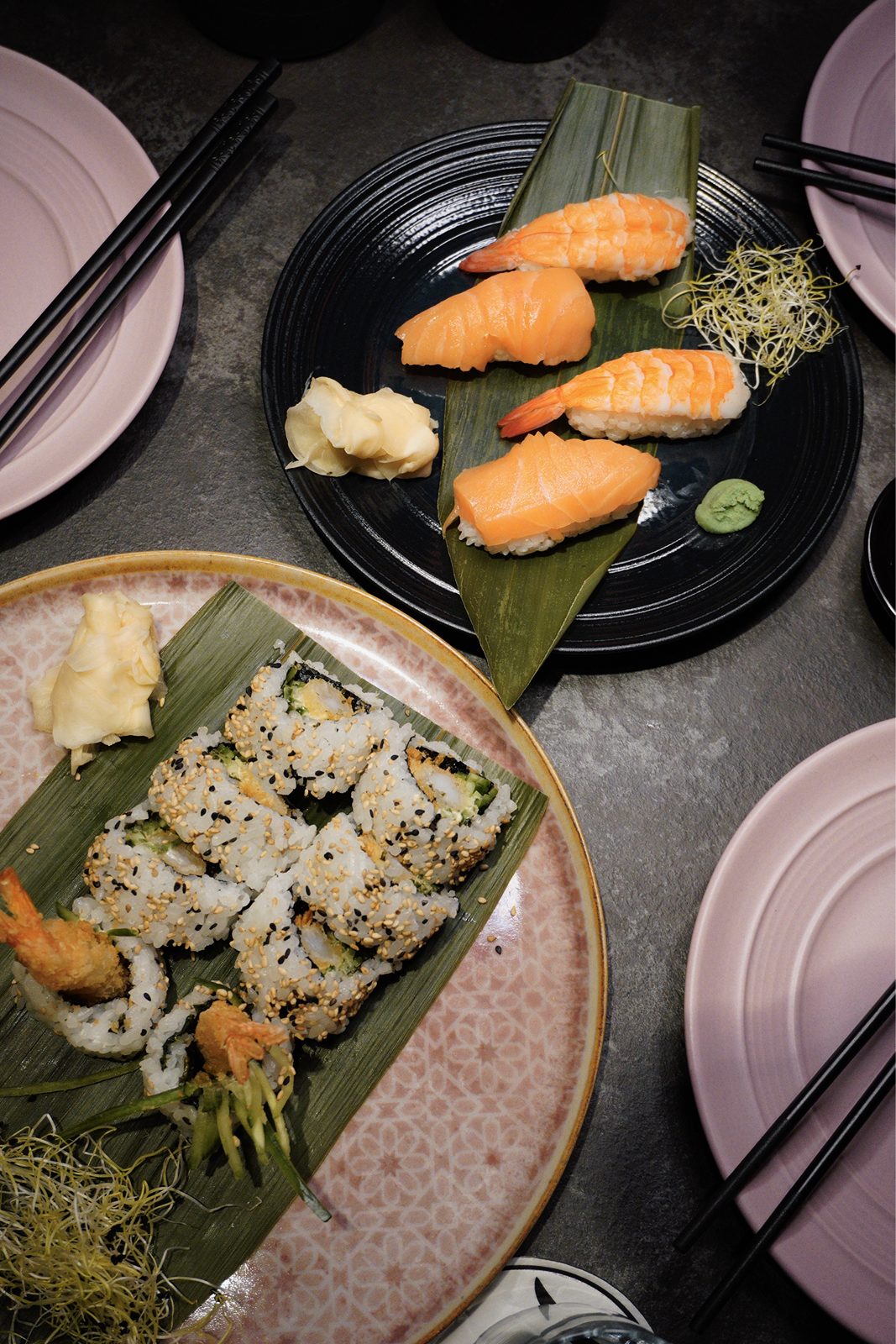 Nigiri mit Lachs und Garnele sowie Sesam-Rolls auf Bananenblatt